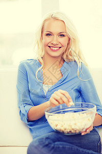 有爆米花的年轻女孩 准备看电影青少年食物小吃长椅微笑幸福女士成人电影房子图片
