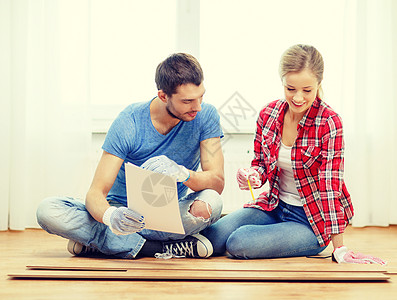 微笑的一对夫妇测量木地板房间木头改造女士男性家庭粮食建筑地板地面图片