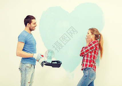 一对在墙上画着大心的情侣女性装潢家庭幸福公寓成人手套滚筒画家乐趣图片