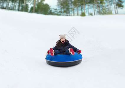 快乐的少女女孩滑下雪管乐趣雪胎管子骑术季节女孩闲暇女士快乐运动图片