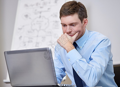 办公室内手持笔记本电脑的商务人士商务学生同事沉思桌子职业男性技术男人领带图片