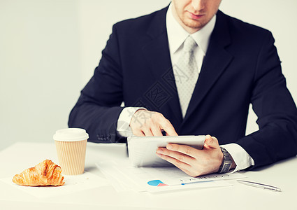 男人用平板电脑和咖啡杯阅读食物工具商务休息会议技术工作合同午餐图片