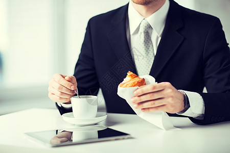 男人用平板电脑和咖啡杯互联网休息技术食物杯子餐饮商务面包套装人士图片
