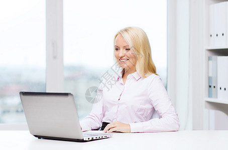 手持笔记本电脑的笑着女商务人士或学生桌子会计女士自由职业者人士工作员工商业技术家庭作业图片