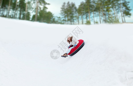 快乐的少女女孩滑下雪管幸福骑术快乐季节假期女孩娱乐女士管子管道图片