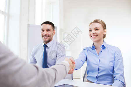 微笑着的女商务人士在办公室握手男人人士同事合伙人员商业合作企业家工人会议图片