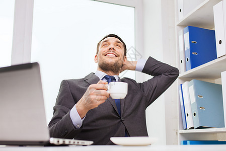 办公室有笔记本电脑打字的商务人士桌子饮料商业领带套装时间男性男人经理杯子图片