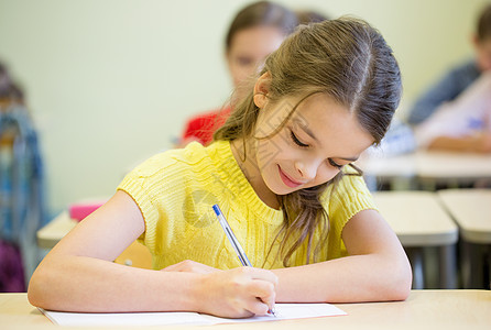 课堂上学生写字考试组数写作考试女孩们青春期微笑桌子童年小学生同学学习图片