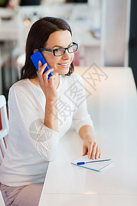 微笑着的女人 在咖啡厅里呼打智能手机女性女孩电话女士拉丁学生眼镜商业自由职业者细胞图片