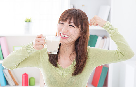 亚洲女性饮奶和显示强壮的臂膀图片