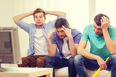 男性悲伤的朋友与Vuvuzela观看运动团体锦标赛伙计们房间友谊游戏沙发男人朋友们屏幕图片