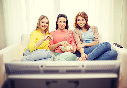 3个微笑的少女 在家中看电视视频电视广播团体食物屏幕青少年成人闺蜜沙发图片