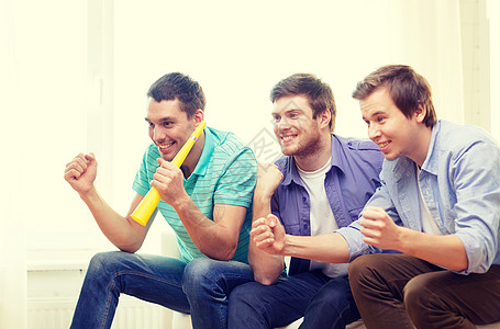 快乐的男性朋友与Vuvuzela观看运动足球青年手表乐趣团体微笑闲暇男人游戏团队图片