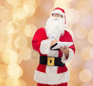 圣诞节狂欢穿着圣塔的装扮和笔记本的人男人男性胡须快乐老年庆典戏服派对假期幸福背景