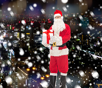 圣诞节狂欢穿着圣塔礼服和礼物盒的人狂欢城市盒子季节传统老年帽子男性戏服礼物背景