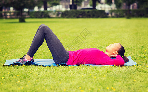微笑着的女士在室外庭垫上做运动护理腹肌损失重量幸福班级女孩青少年训练身体图片