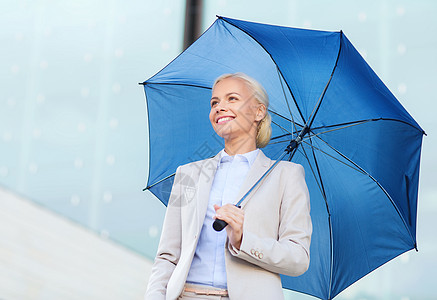 年轻 笑着的女商务人士 在户外配有伞式雨伞街道工人经理女士保险管理人员人士危机商务生意人图片