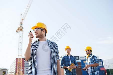 一群微笑着的建筑者 用收音机用硬帽男性技术同事工人财产团队快乐眼镜建筑师团体图片