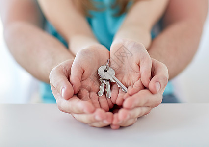 男人和女人手紧贴着房钥匙杯状抵押财产童年女儿房子机构身体家庭一部分图片