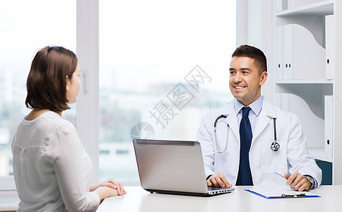 带着微笑的医生和年轻女性在医院聚会药品电脑咨询治疗处方桌子互联网诊所心脏病技术图片