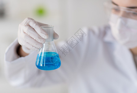 在实验室里用酒瓶做测试的近身女人生物风镜临床科学家外套研究样本化学家烧瓶化学图片