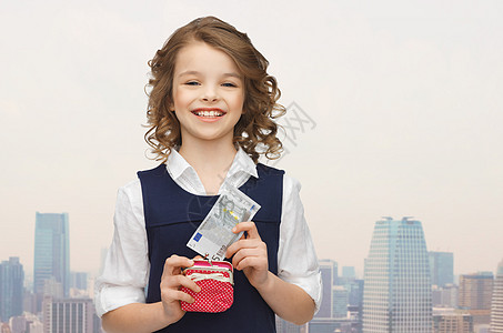 带着钱包和纸钱的快乐女孩投资建筑物经济机构财富微笑推杆摩天大楼笔记货币图片