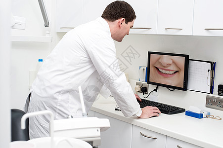 在牙科诊所使用计算机的牙医医生医疗技术桌子监视器白色检查卫生牙齿专家键盘图片