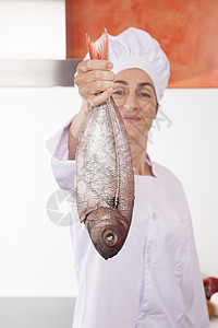 鱼在快乐的女厨师手中图片