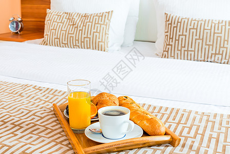 在旅馆房间的床上用餐盘和健康早餐图片