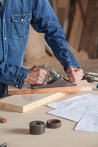 在其工作间工作的木匠灰尘工人工具木工桌子财产作坊刨床男人木材图片