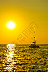黄金日落时的卡塔马兰帆船双体热带血管闲暇海浪旅行反射游艇阳光旅游图片