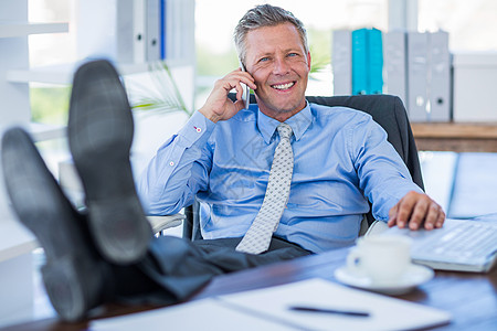 商务人士在摇摇椅上放松一下 并且打个电话办公室笔记本电脑屏幕咖啡呼唤旋转沟通公司商务图片