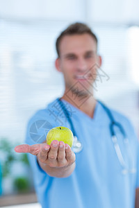 展示绿苹果的笑脸医生红色微笑工作外科绿色快乐饮食保健医院健康饮食图片