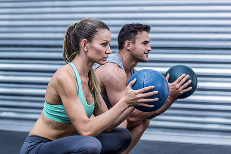 做球锻练的肌肉夫妇健身快乐实心运动员健身房运动服专注闲暇微笑健身室图片