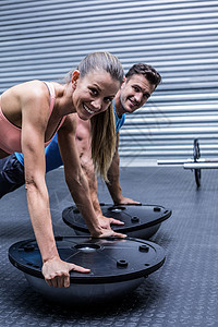 做波苏球锻练的肌肉夫妇调子微笑朋友男性平衡培训师体质护理健身女士图片