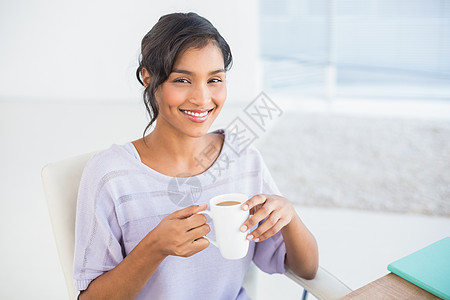 在办公桌喝咖啡的临时商业女商务人士人士商务办公室桌子混血电脑屏幕衬衫休闲工作图片