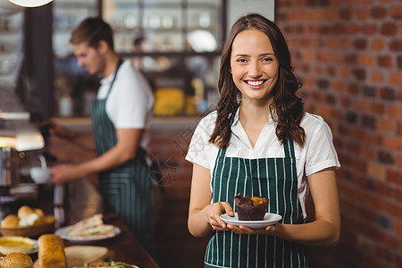 蛋糕服务器漂亮的女服务员拿着盘子和松饼背景