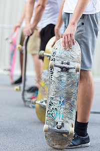 男孩在街上玩滑板 城市生活男性城市行动活力伙计们青年团体轮子朋友们溜冰者图片
