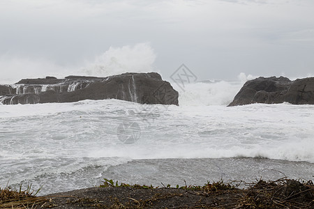 海浪撞击岩石的暴风海飓风多云海啸海景天空气旋泡沫危险海岸地平线图片