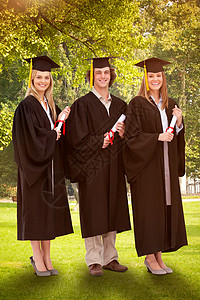 3名身着研究生袍 带着毕业文凭的微笑学生的综合形象长袍女性成就植物区系叶子土地女士勘探树干图片