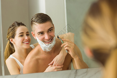 女人用剃须泡沫泡在男朋友脸上家庭生活镜子剃须膏男人鼻子快乐公寓反射男性女性图片