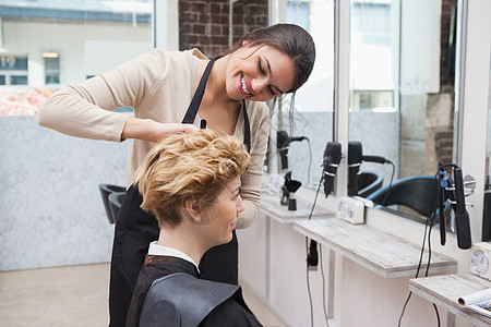 快乐的理发师剪客户头发商务沙龙发型微笑理发造型师美发女士人士工作图片
