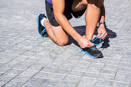 阿图莱特在阳光明媚的日子绑鞋带短裤手表都市鞋类护理锻炼运动鞋风光运动员运动服图片