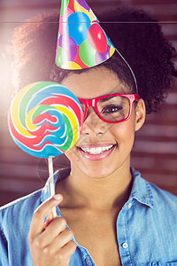 糖果色躲在棒棒糖背后的嬉皮士肖像粉色女性女士气球小吃帽子混血微笑红色生日背景