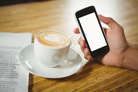 拿铁咖啡艺术咖啡和智能手机高角闭合宏观杯子艺术技术泡沫咖啡师勺子饮料男人男性背景