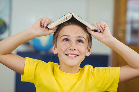 微笑的学生在课堂上头顶着书童年瞳孔桌子学校班级男性知识早教小学生学习图片