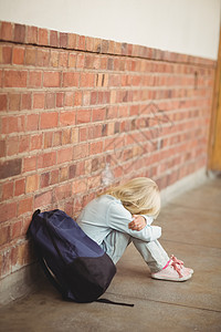 孤单坐在地上的悲惨学生孤独童年学校女性瞳孔小学忧郁走廊寂寞小学生图片