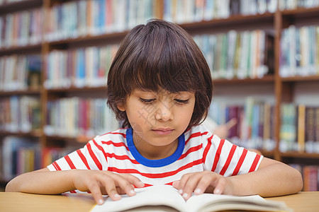 图书馆书桌旁的小学生阅读书学校桌子小学瞳孔学习知识小学生混血班级童年图片