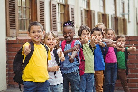 外面有书包的可爱学生手势微笑沟通瞳孔女孩小学生同学们朋友女性快乐图片