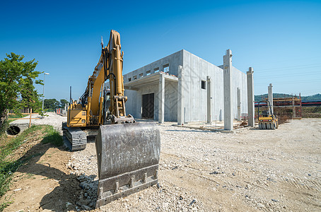 新建筑工地的大型挖土机 背景是Bl活动工业挖掘机建筑学房子机器车辆机械地球土地图片